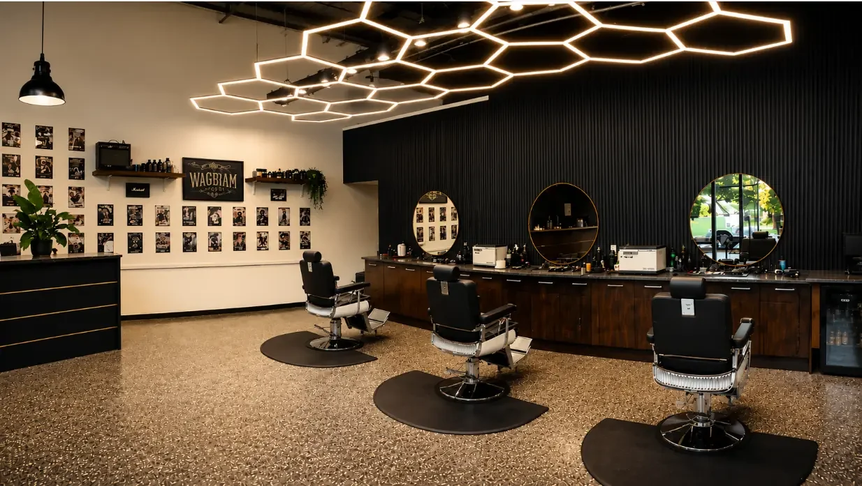 Interior of Wigram Barbers at The Landing Wigram with three barber chairs, round mirrors and modern geometric lighting