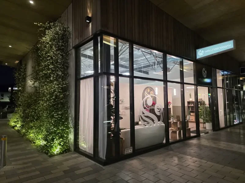 Wellnescessity Wigram clinic exterior illuminated at The Landing in the evening