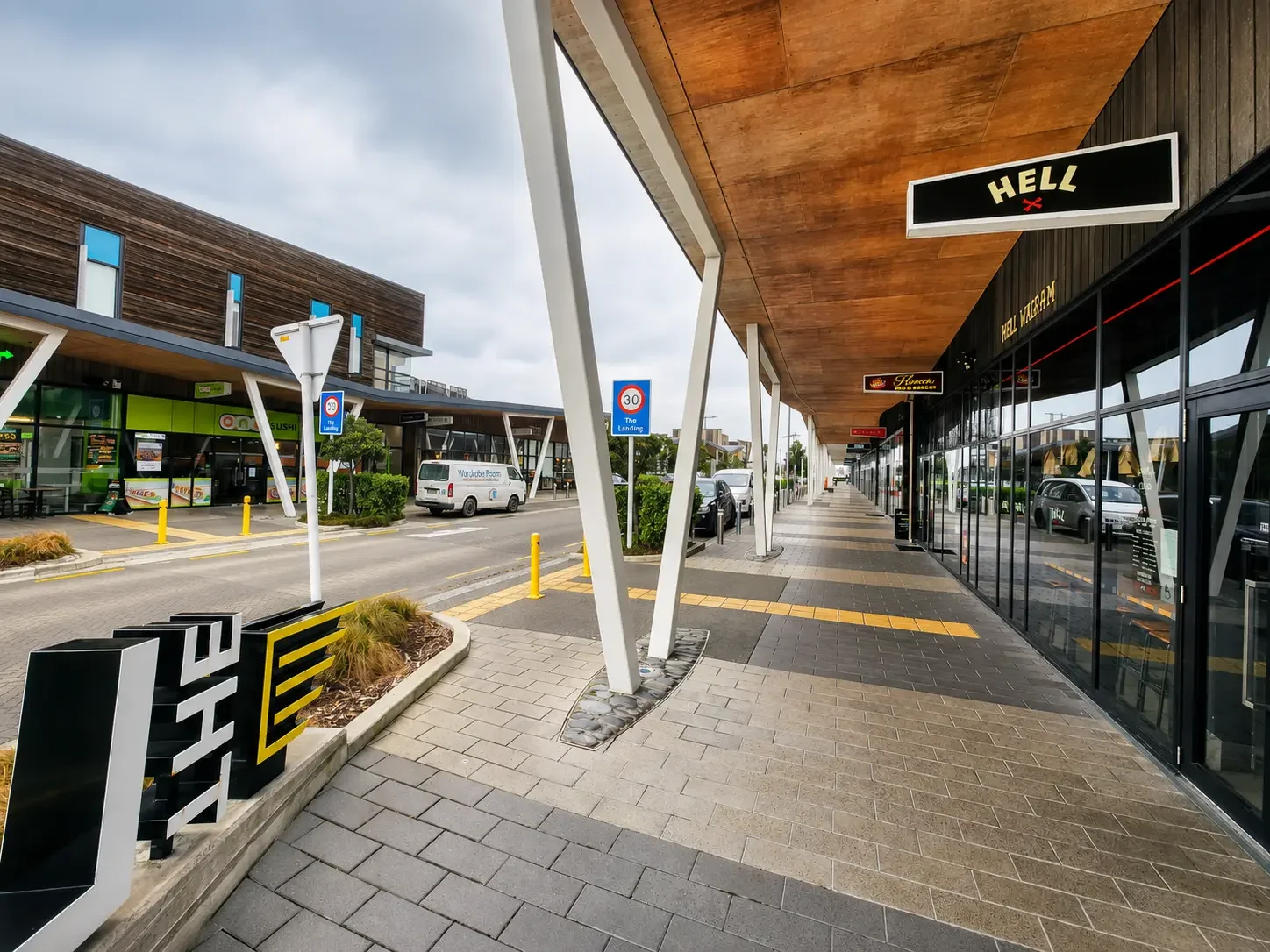 Covered shopping walkway with stores and restaurants at The Landing Wigram in Christchurch