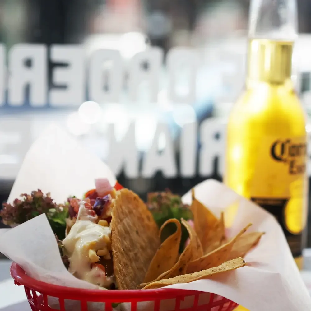 Mexicali Fresh tacos served with tortilla chips and a Corona