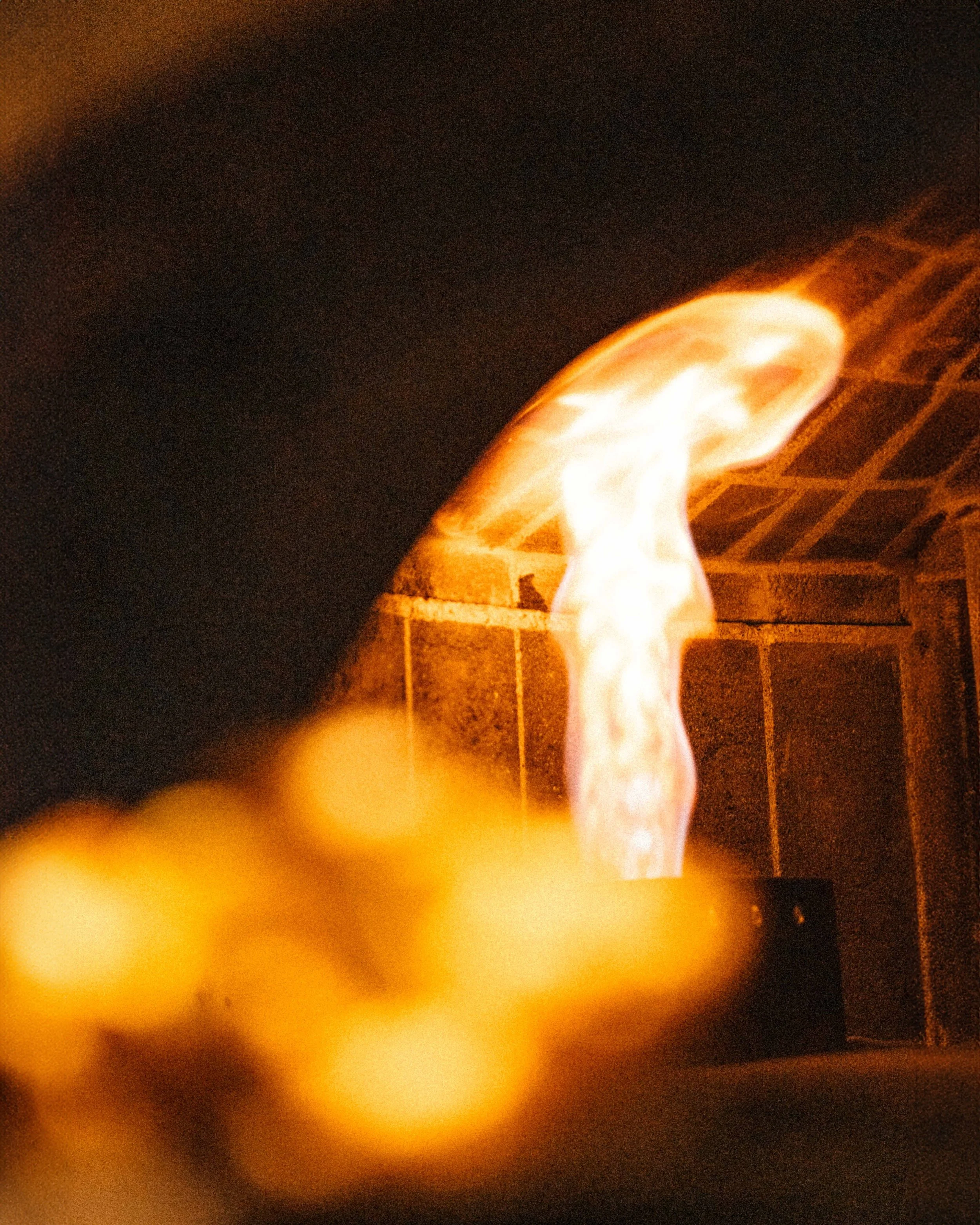 Close-up of a fire or flame against a dark background with orange and yellow hues.