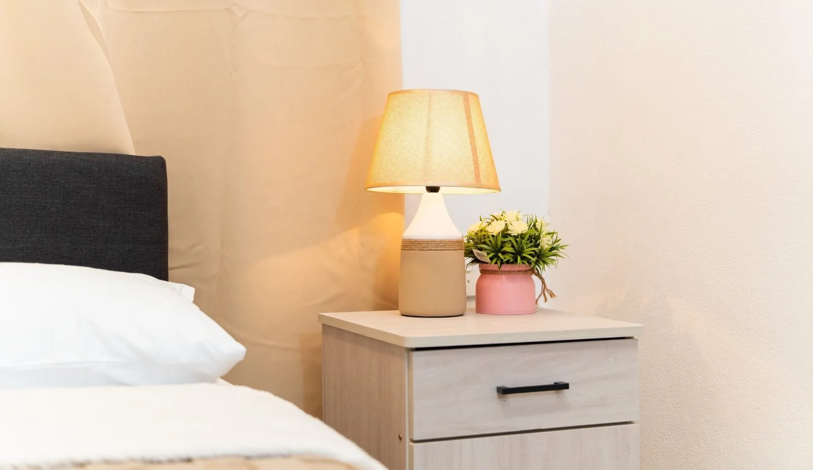 Calm bedroom corner with soft lamp light and a small plant at the Garden Flat, Nausori