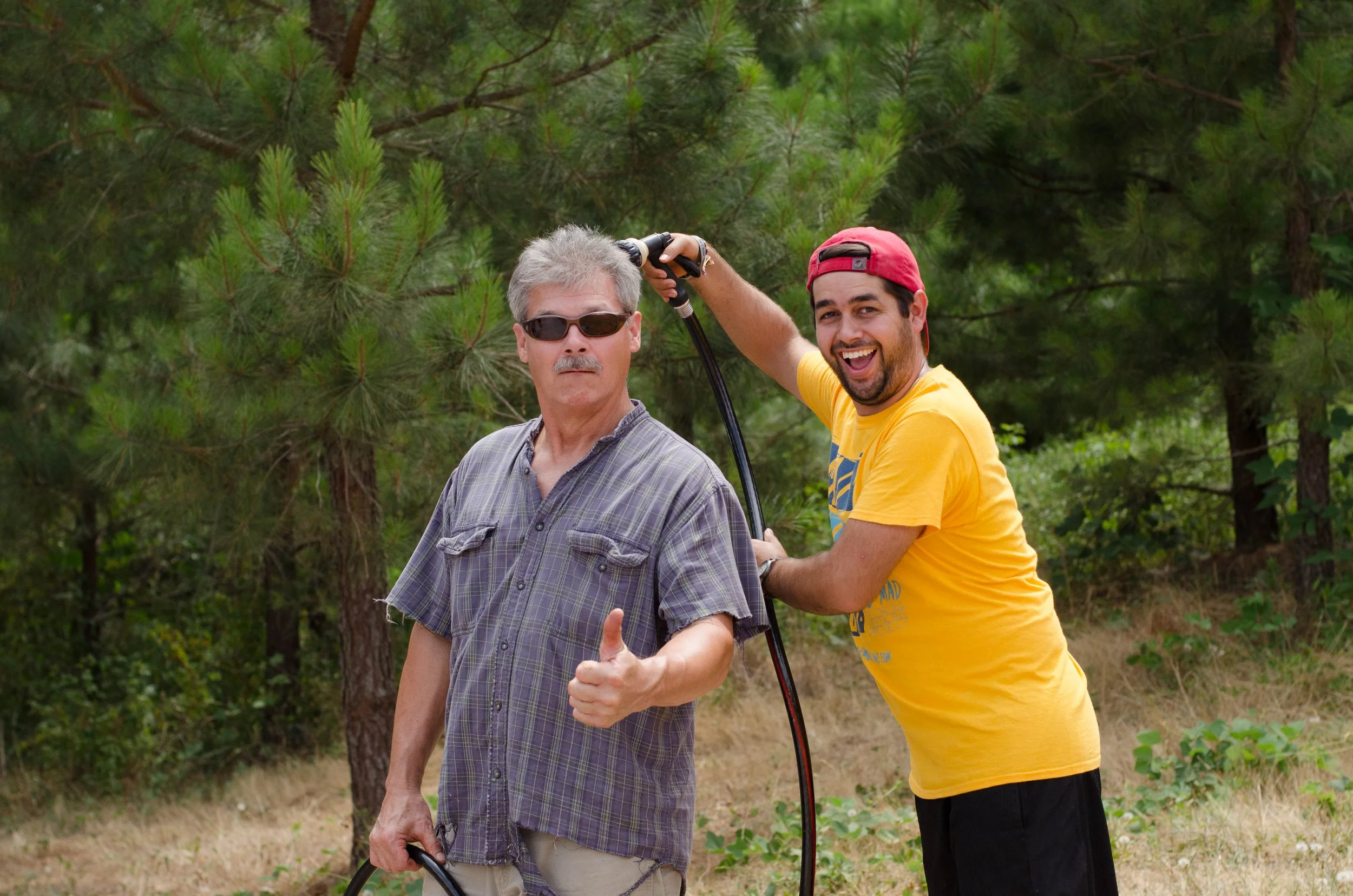 Camp Counselor, spraying another counselor with a water hose