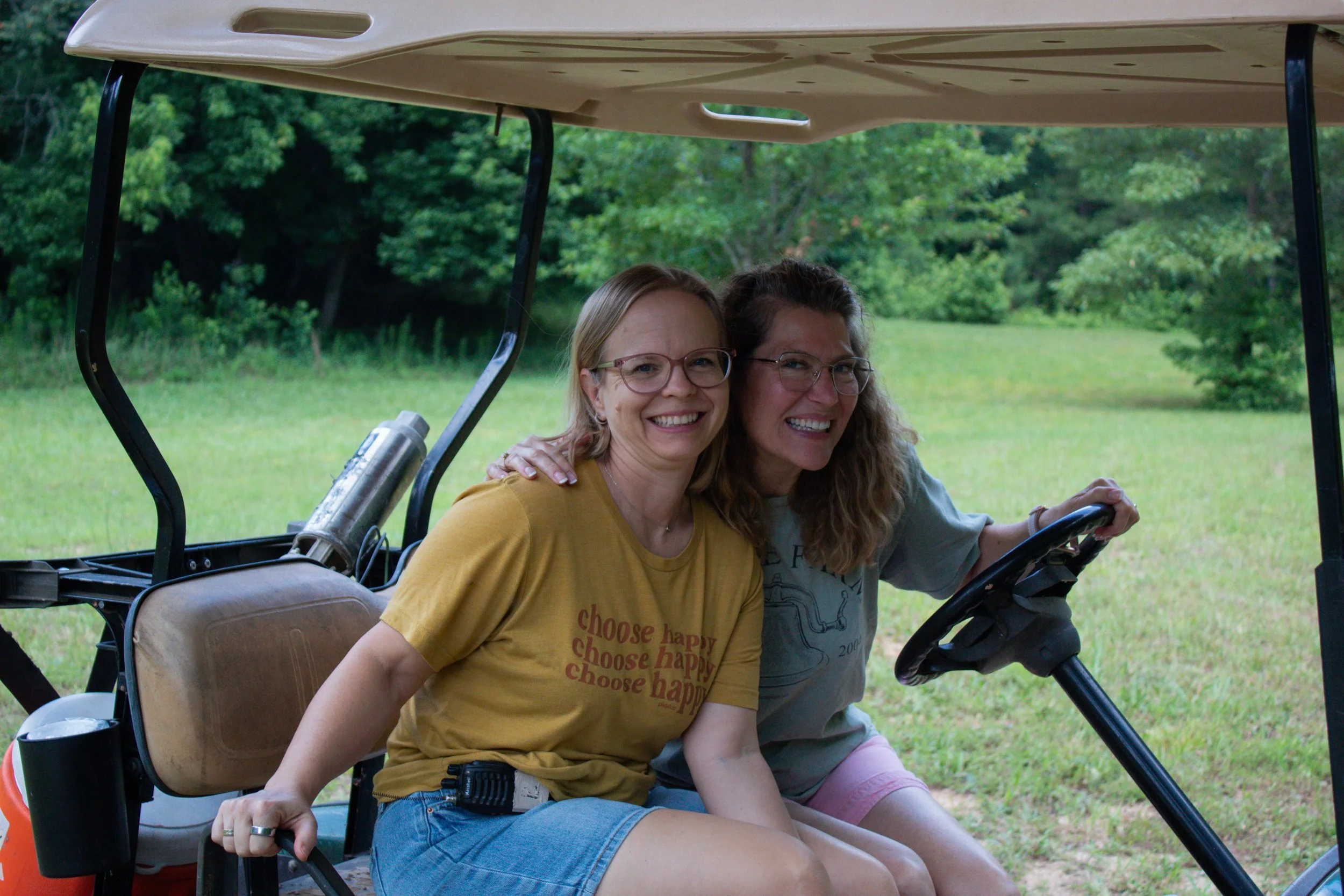 Two counselors driving the golf cart and having fun together