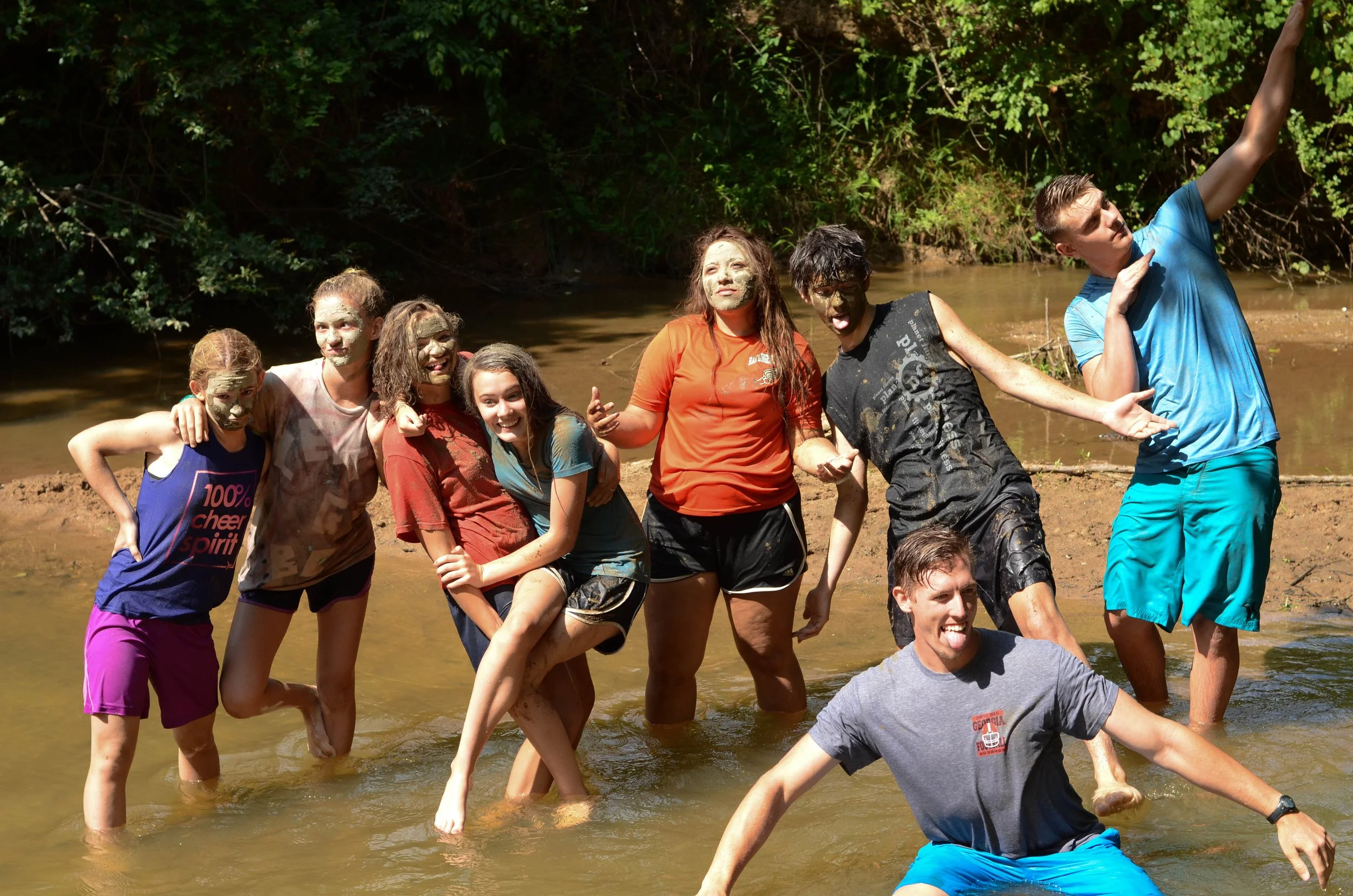 Group of campers posing for a picture in the creek