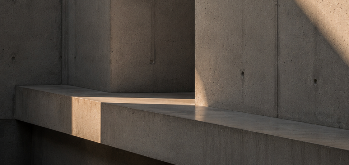 Close-up of concrete architectural structure with a ledge and shadows.