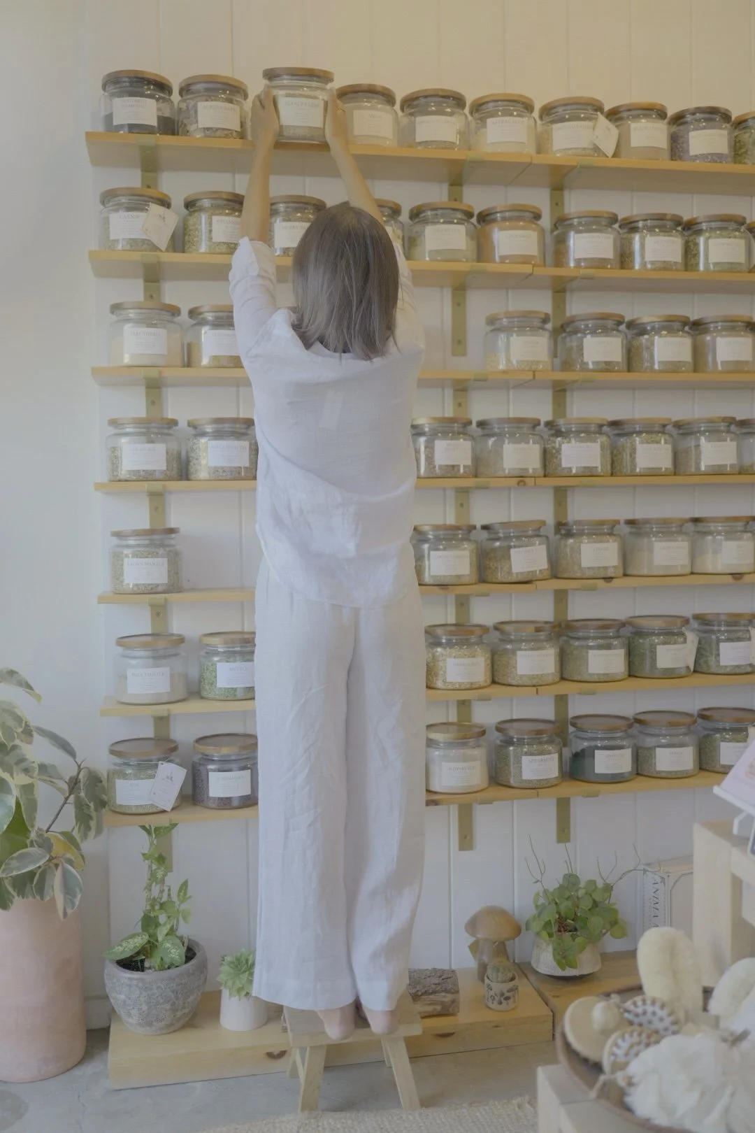 Naturopathic doctor reaching for herbs on an apothecary shelf