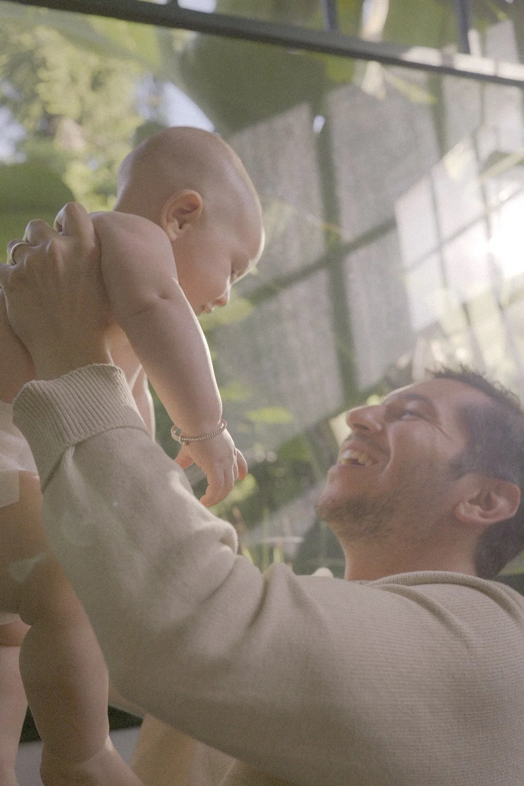 Father lifting his baby overhead outdoors