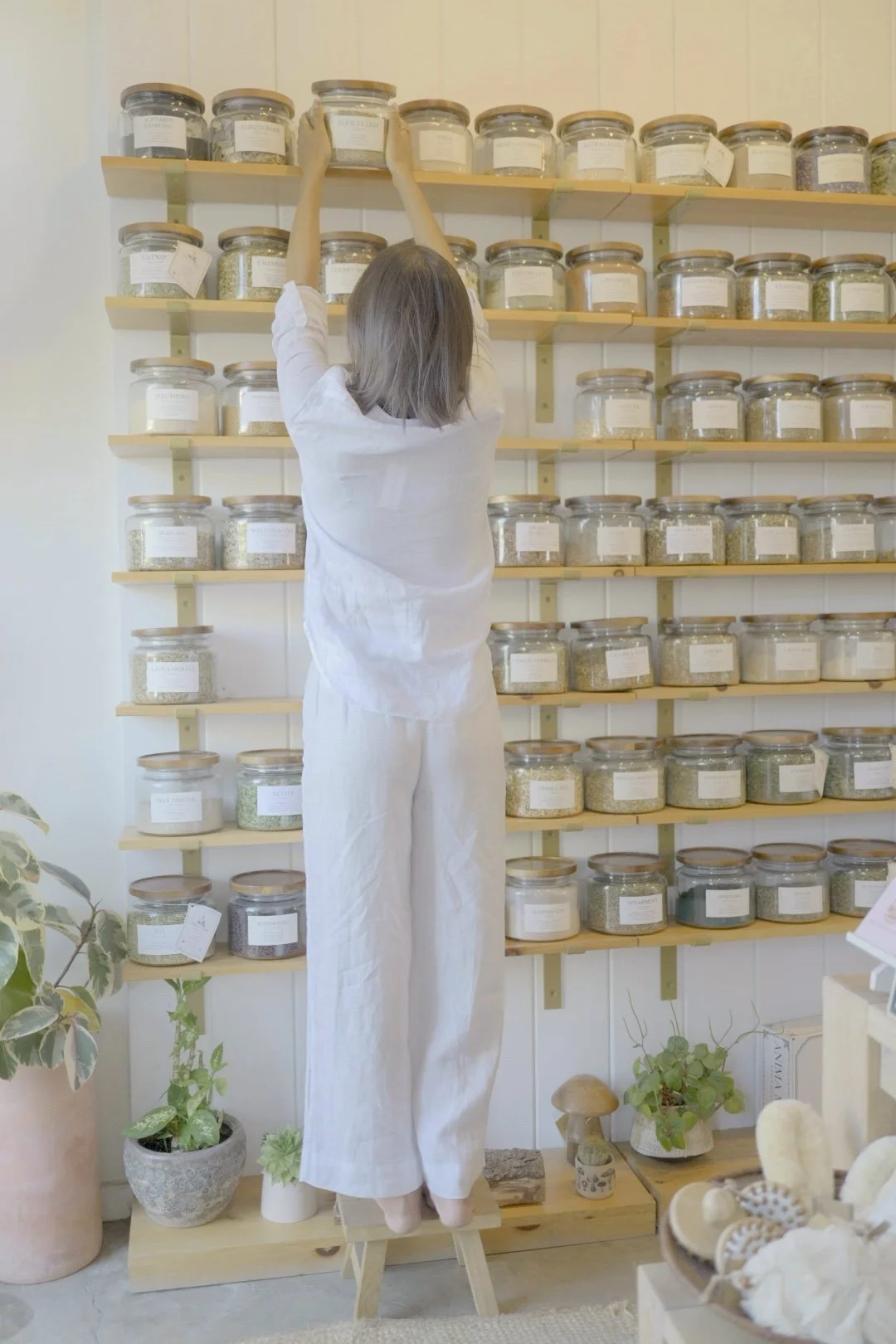 Naturopathic doctor reaching for herbs on an apothecary shelf
