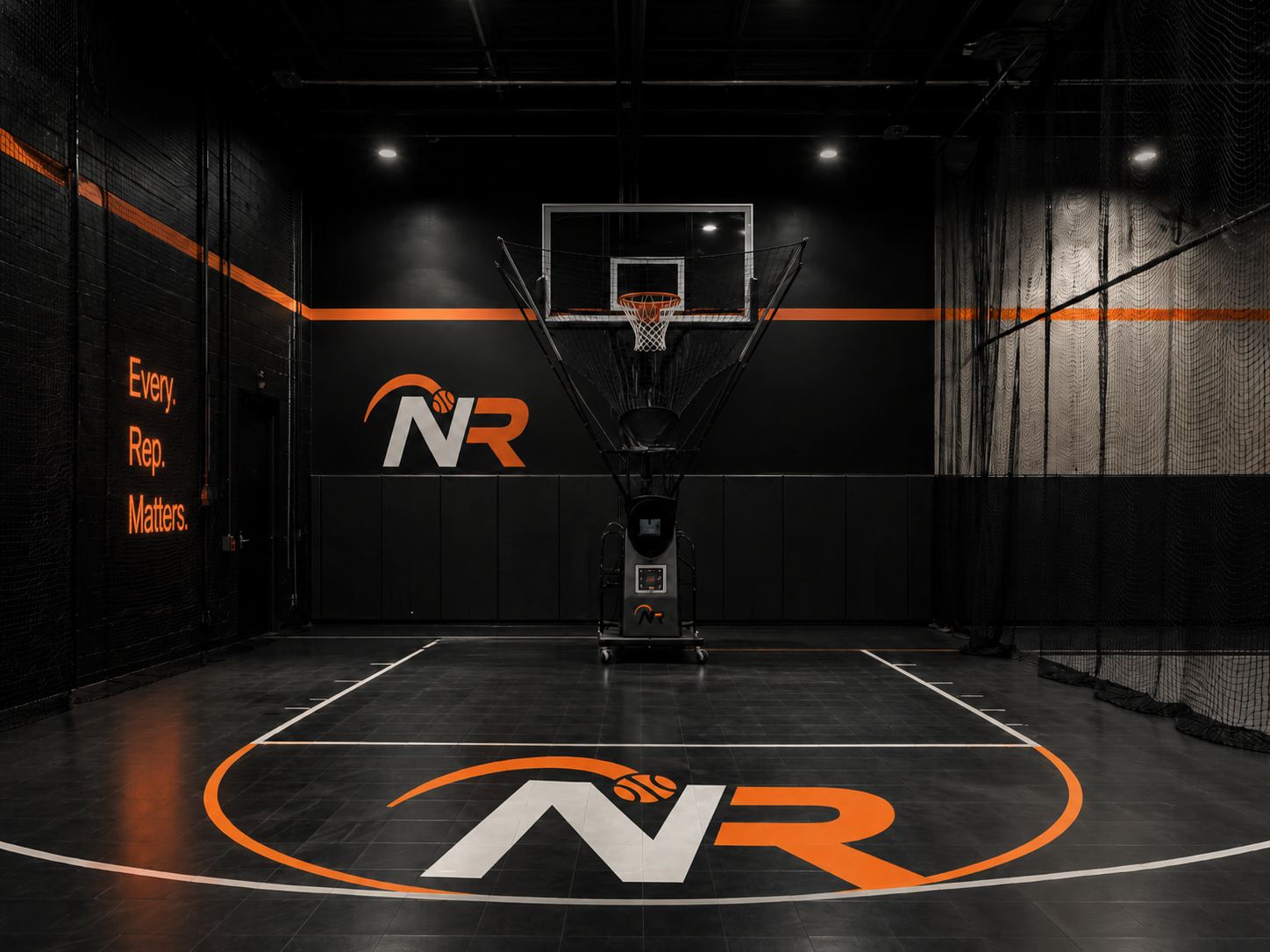 Indoor basketball court with black walls and floor, featuring orange and white branding, a mounted basketball hoop, and a large logo on the floor. The wall on the left displays the phrase 'Every. Rep. Matters.' in orange text.