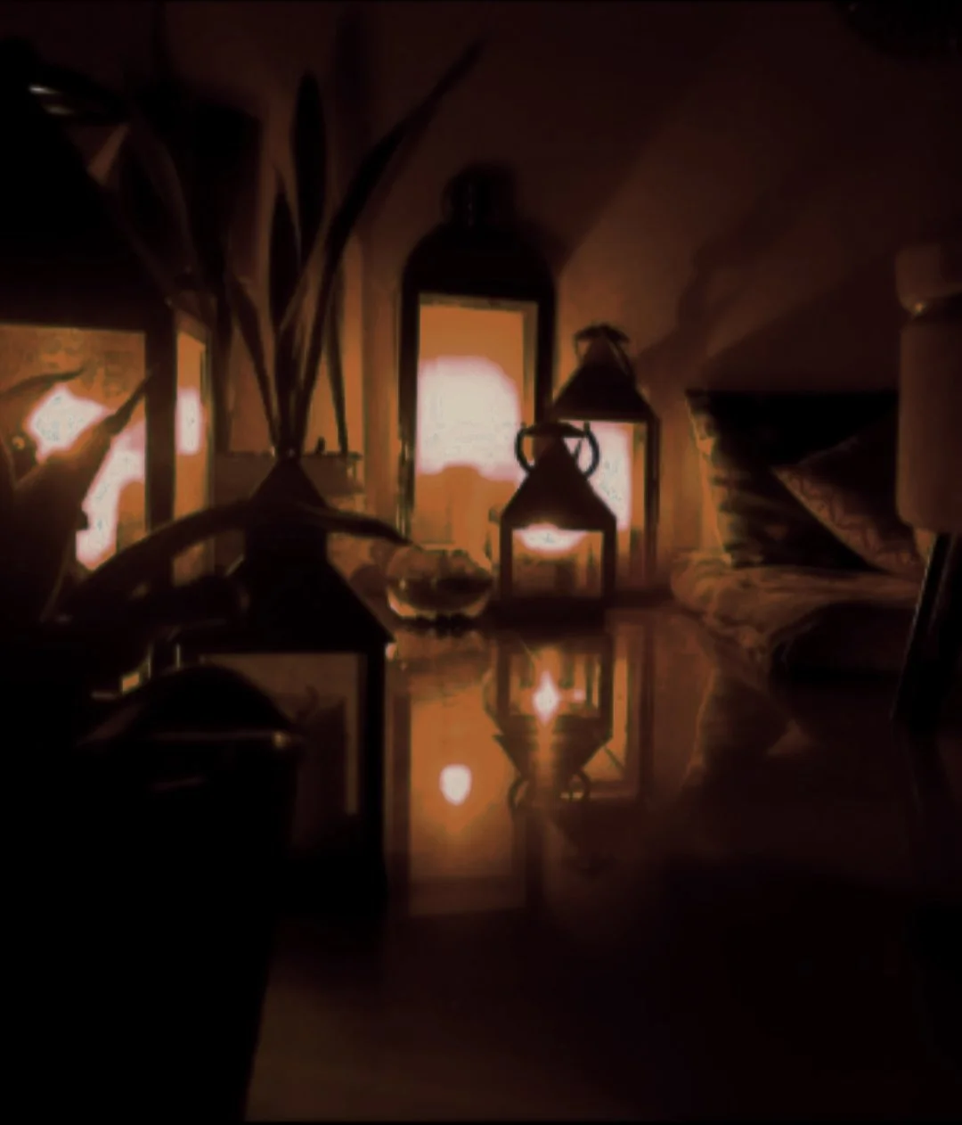 Warm candlelit interior with layered lighting and reflective surfaces, creating an intimate spatial atmosphere.