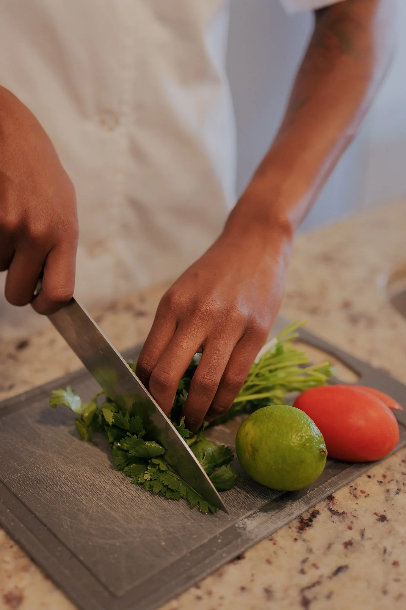 Chef Kaye preparing fresh herbs and vegetables for a private catering event in Dallas - The Culinary Gallery farm-fresh ingredient prep