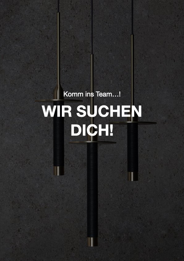 Drei Hantelstangen hängen an der Decke gegen eine dunkle Wand, mit der weißen Schrift "Komm ins Team…! WIR SUCHEN DICH!" im Vordergrund.
