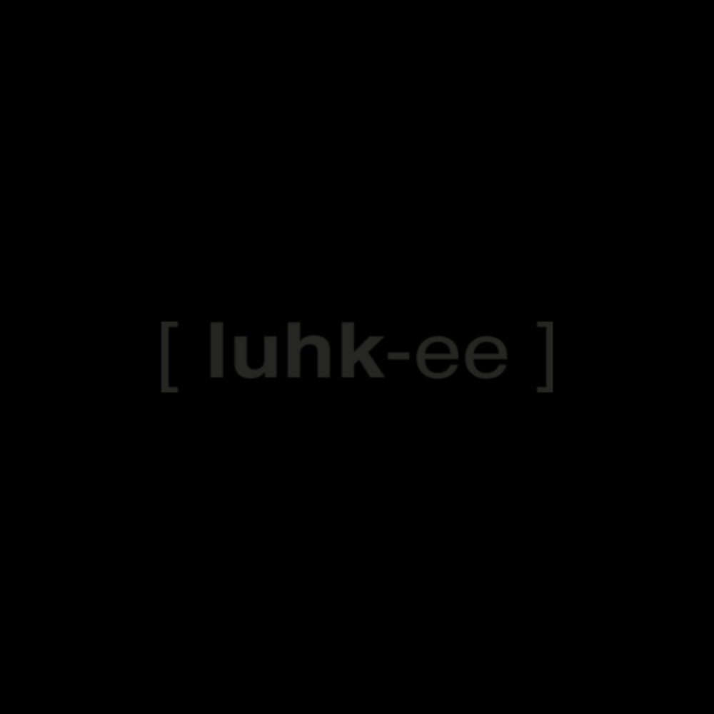 Ein Wackeldackel auf einem Autoschloss, das Wort 'luhk-ee' in der Mitte