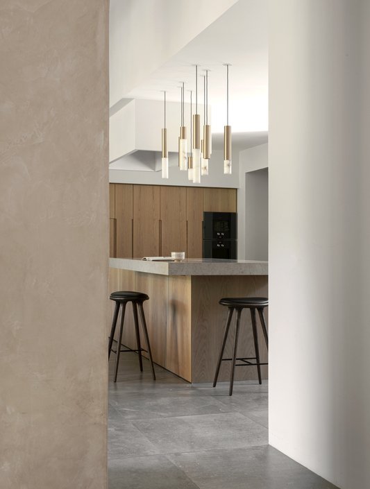 Moderne Küche mit Holzfronten, barhockern, einer Stehlampe und einer Kochinsel.