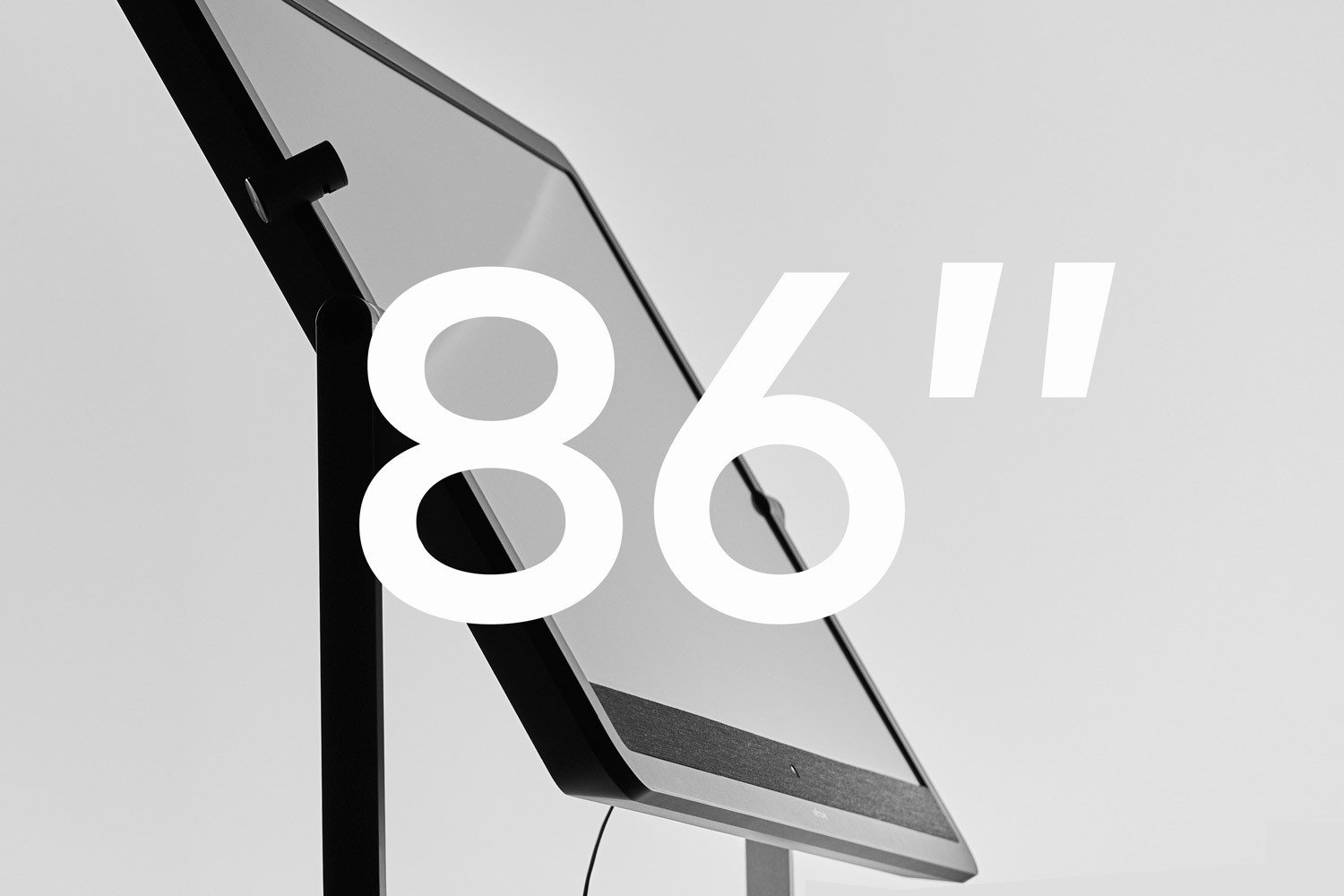 Schwarzer iMac-Computer mit einer großen weißen Zahl 86 und einem Anführungszeichen, auf grauem Hintergrund.