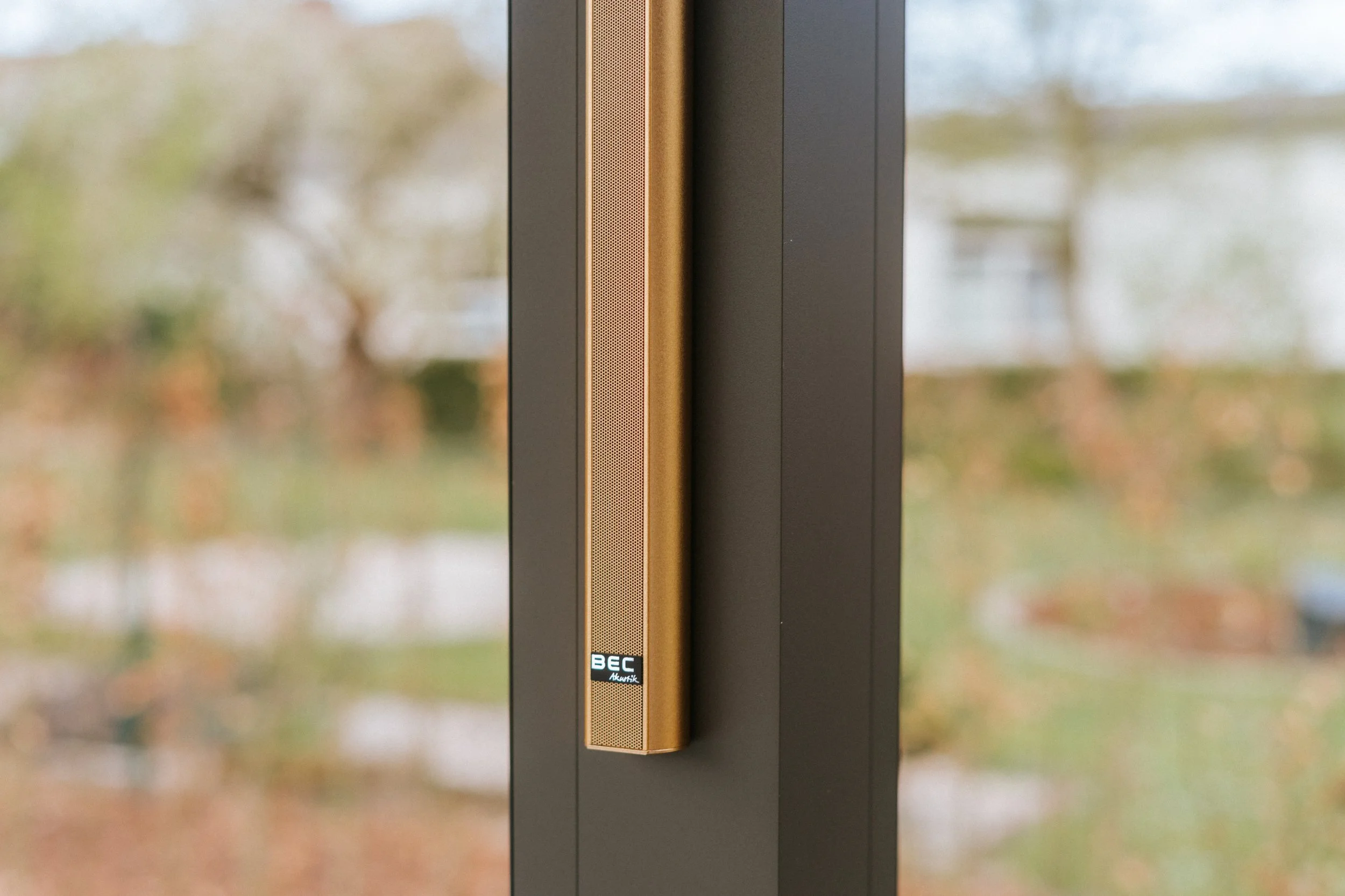 Nahaufnahme eines schwarzen Fensters mit goldenem Lautsprecher an der Seite