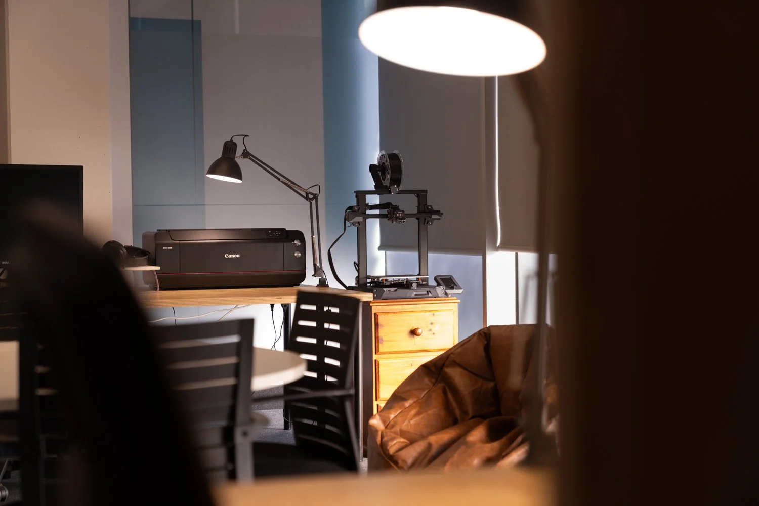 Members workspace featuring a Canon A2 photo printer, film scanning station, meeting table, and editing workspace.