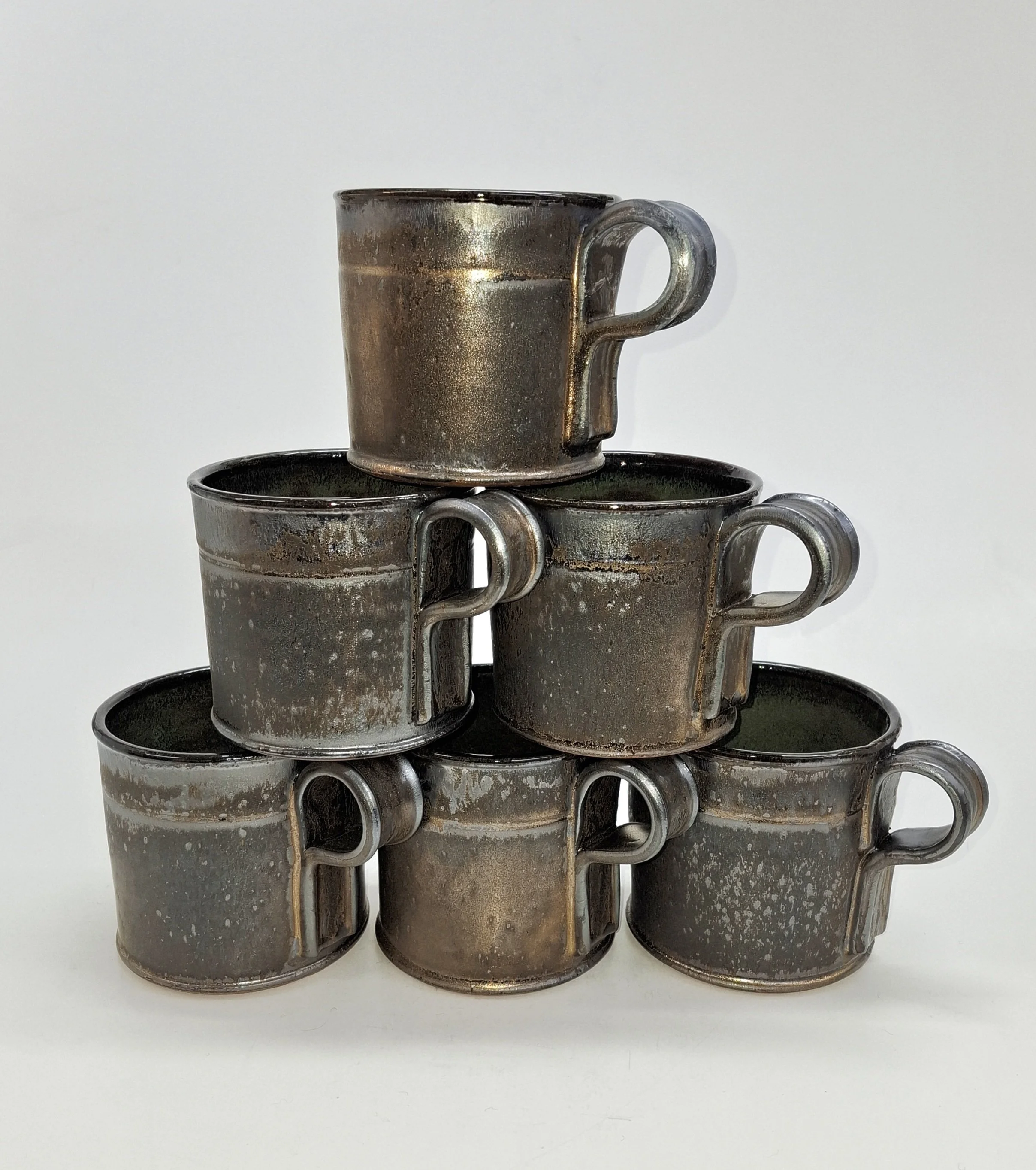 Stack of metallic coffee mugs on a white background.
