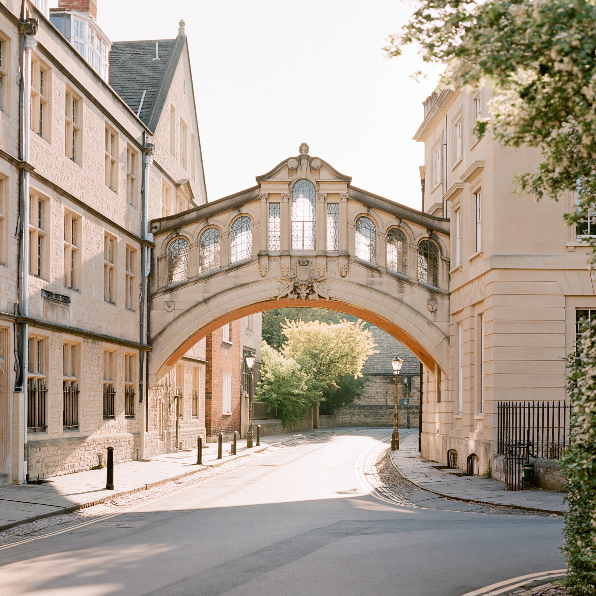 Historic university campus with an ornate stone bridge connecting two academic buildings.