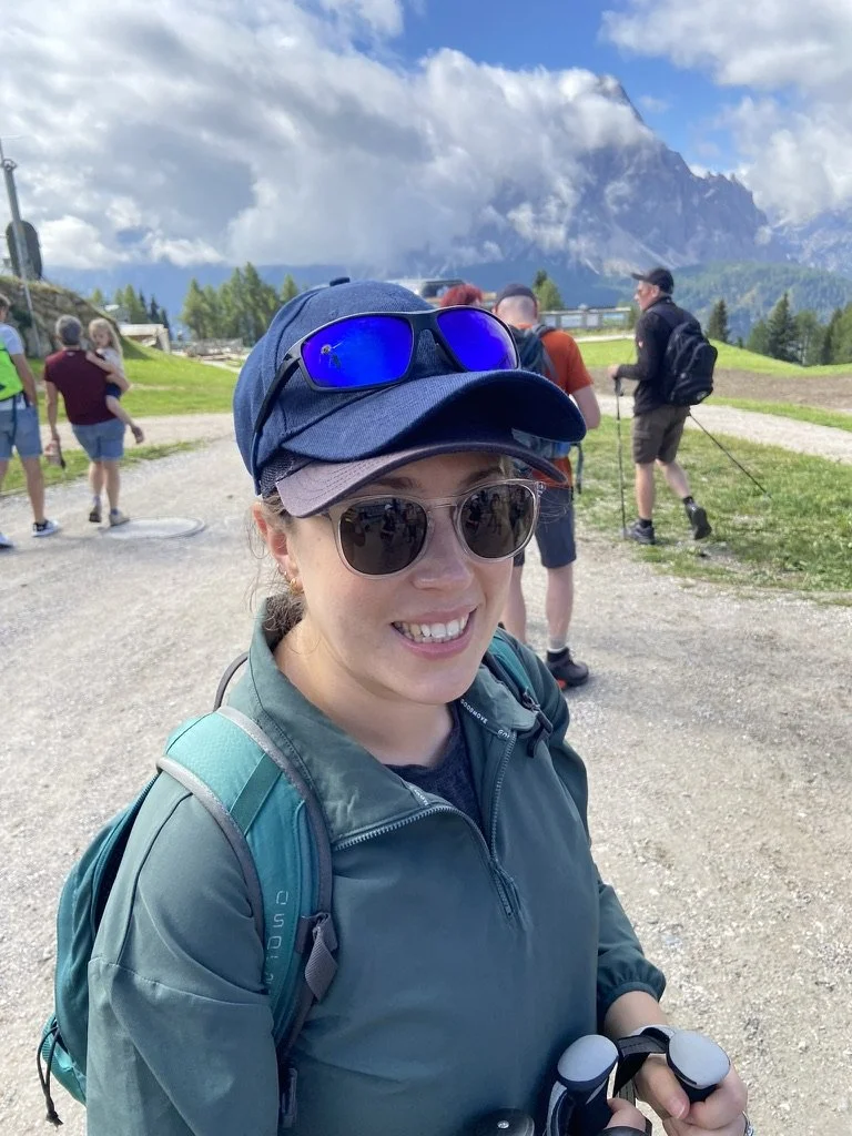 Coach in hiking gear wearing two hats
