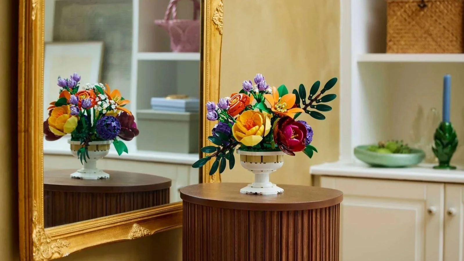 LEGO Flower Arrangement set in its brick-built white vase on a round wooden table next to a gold-framed mirror