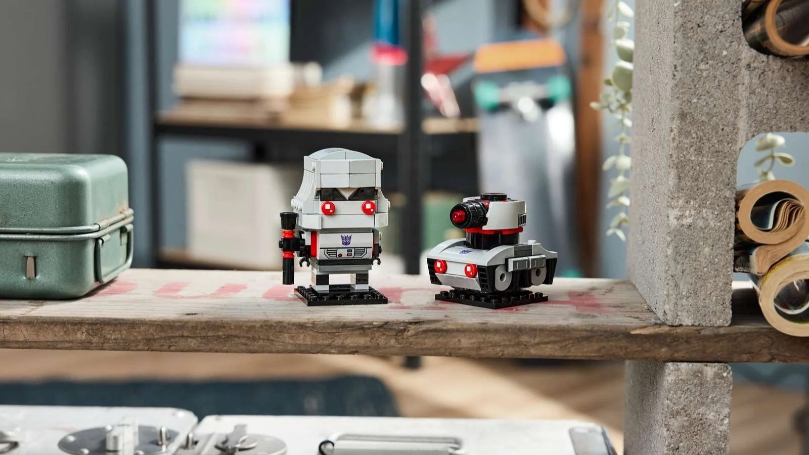 LEGO Megatron Robot and Vehicle set with a gray and white Megatron figure and its small tank vehicle side by side on a wooden shelf