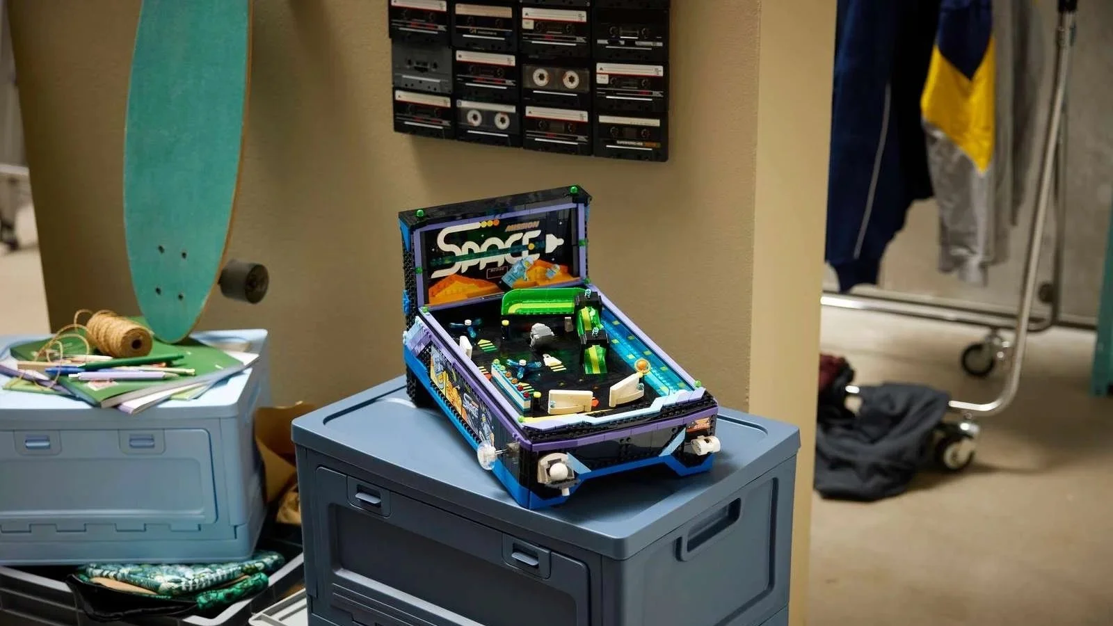 LEGO Arcade Pinball Machine set with a space theme, displayed on a stack of storage crates near a skateboard