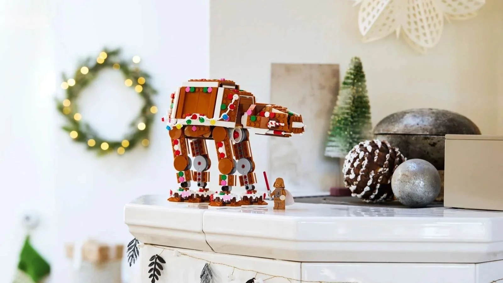 LEGO Star Wars Gingerbread AT-AT Walker covered in colorful candy dots, with a gingerbread Darth Vader minifigure on a white mantel