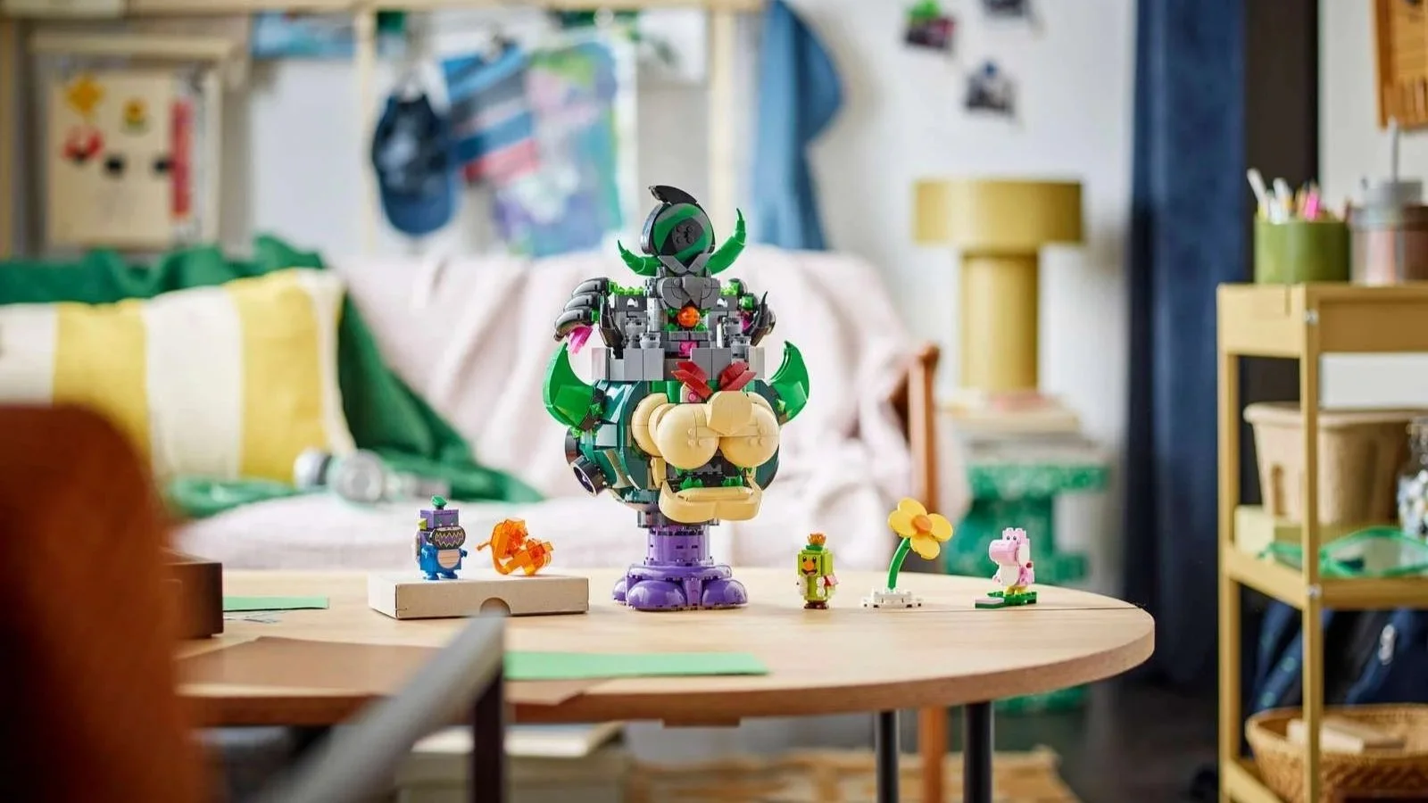 LEGO Prince Florian and Castle Bowser set on a round wood table, with Yoshi and other Super Mario figures nearby in a colorful living room