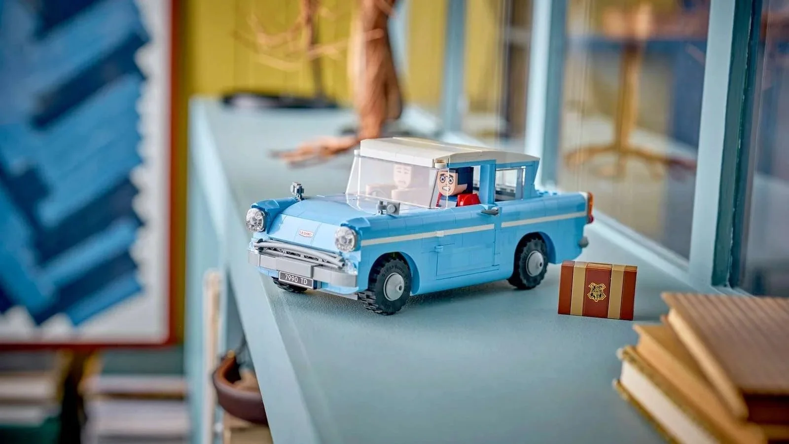 LEGO Enchanted Flying Ford Anglia set with Harry and Ron minifigures parked on a windowsill beside stacked books