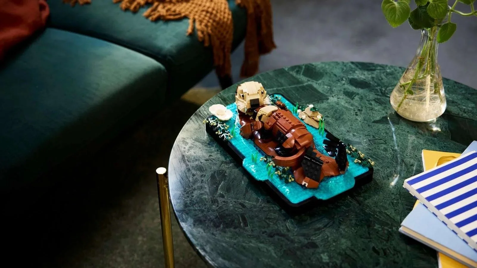 LEGO sea otters floating together on the water, displayed on a green marble side table