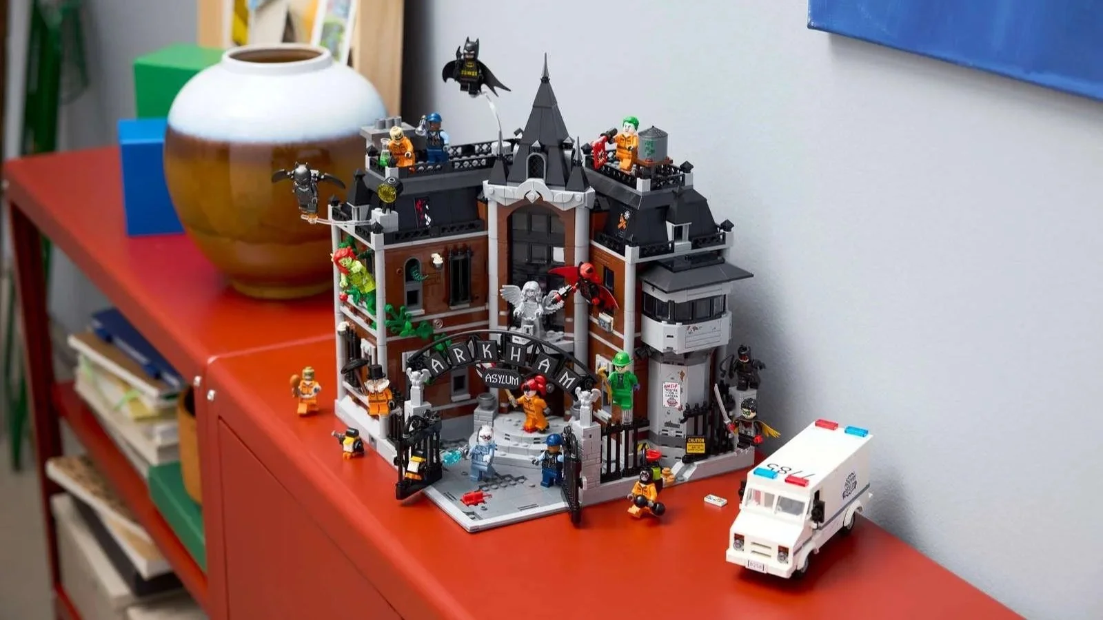 LEGO Arkham Asylum set with Batman and villain minifigures displayed on a red sideboard