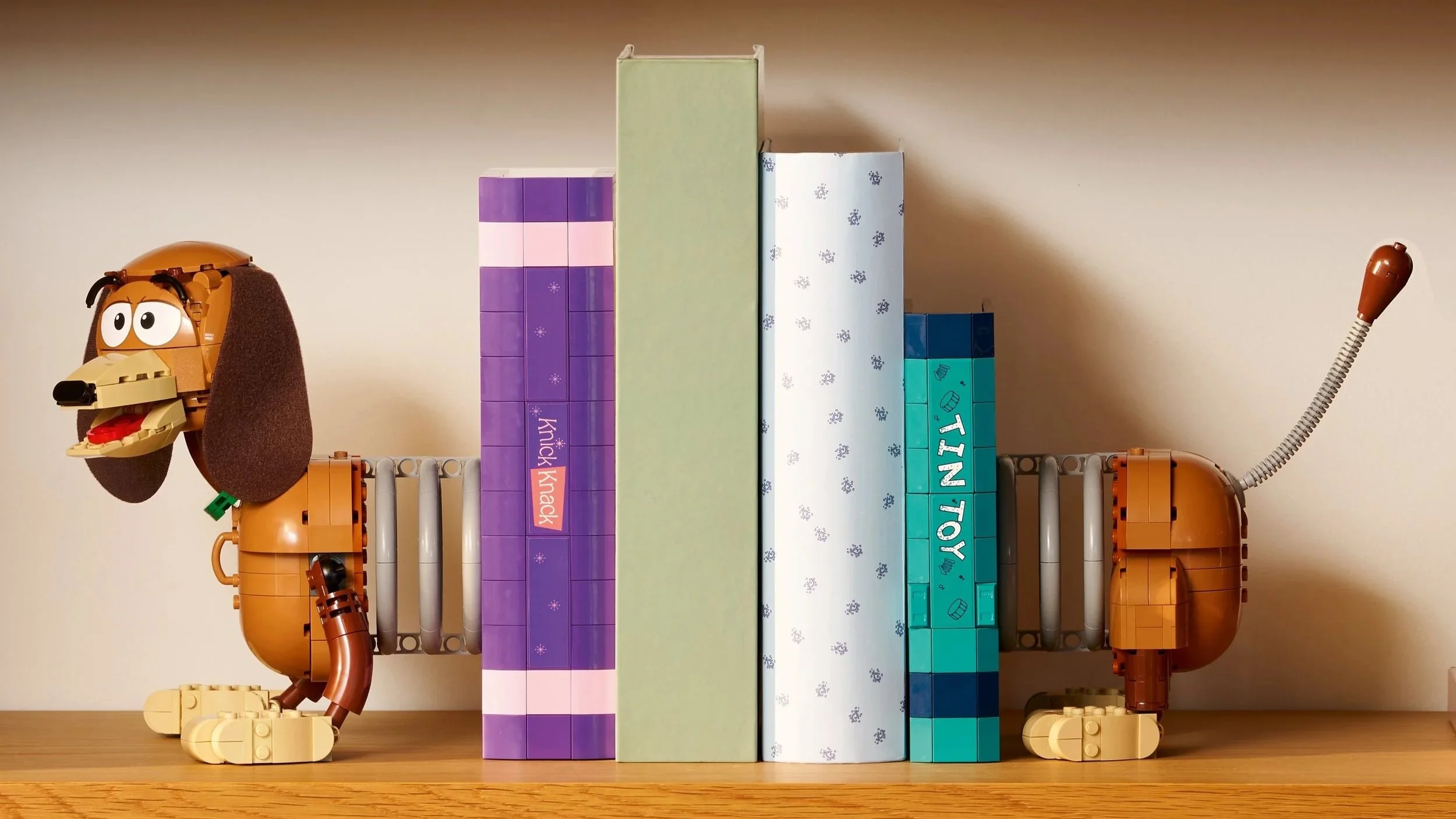 LEGO Toy Story Slinky Dog Bookends set holding a row of books upright on a wooden shelf