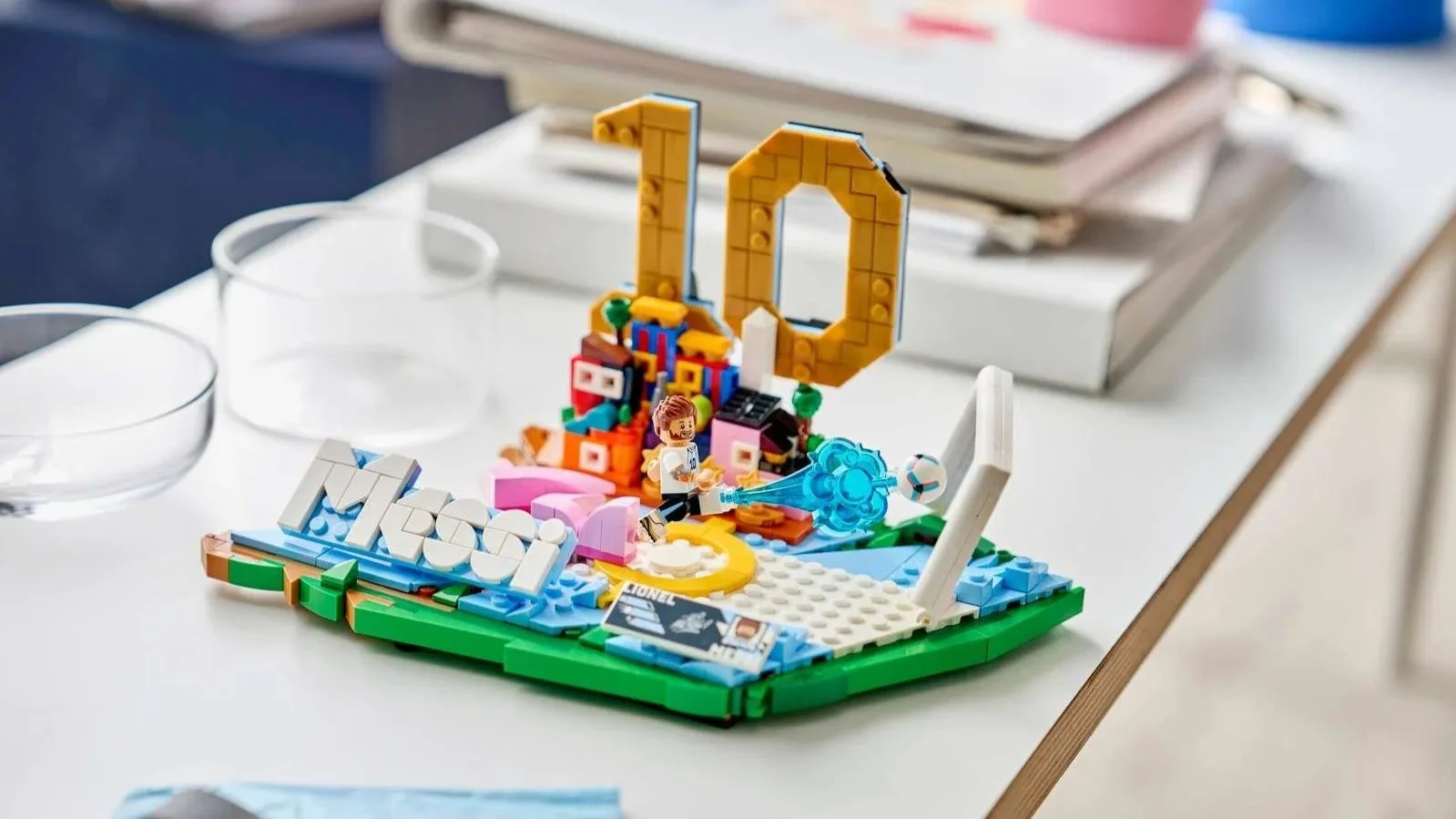 LEGO Lionel Messi Soccer Highlights set on a white desk, with a Messi figure kicking a ball toward a goal beside a gold number 10