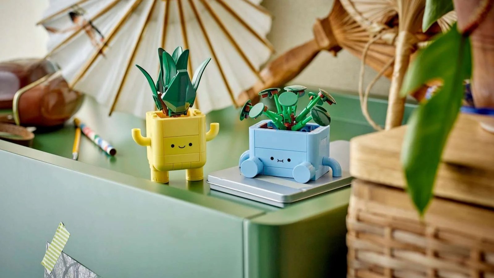 LEGO Happy Plants set with smiling yellow and blue planter characters on a green desk