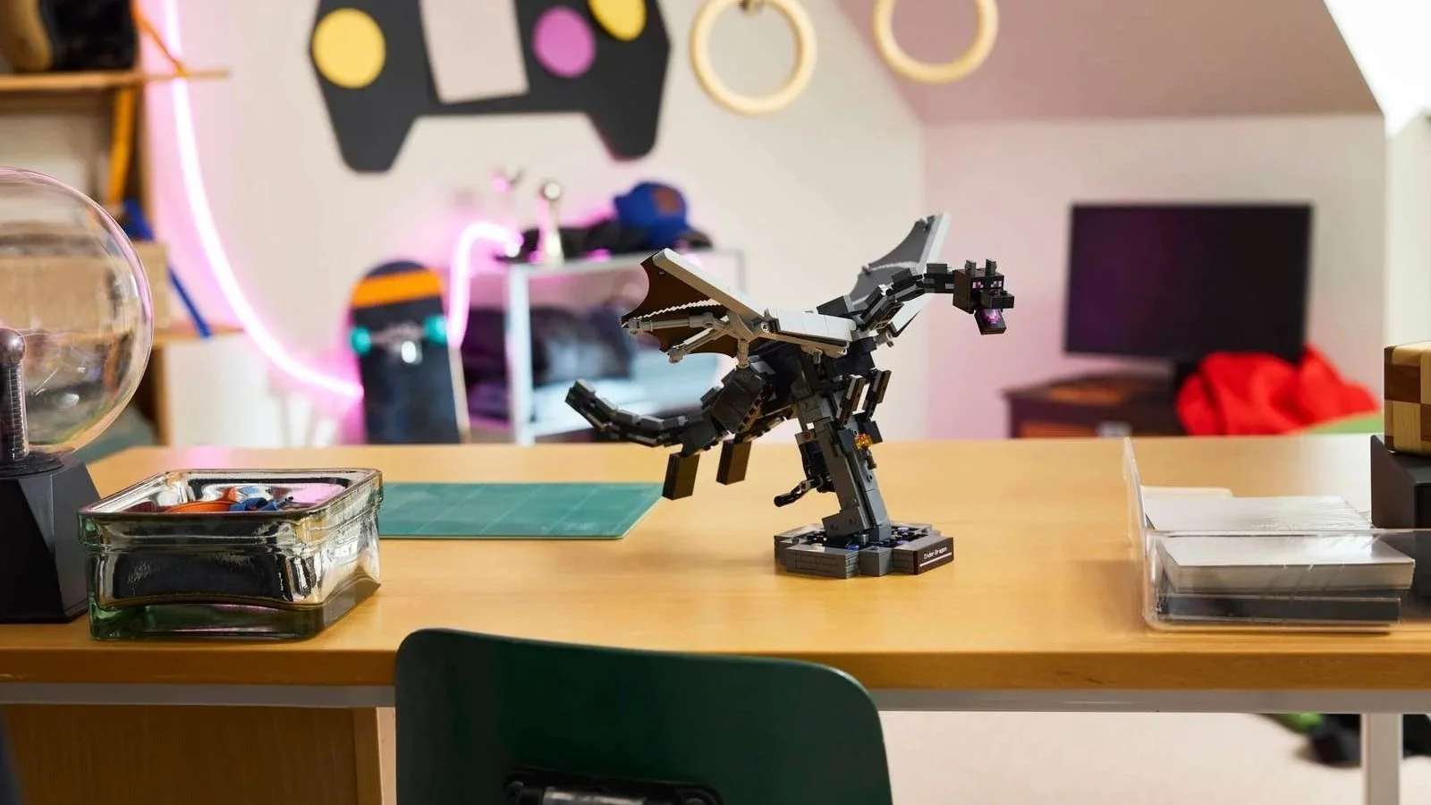 LEGO Minecraft Ender Dragon figure with wings spread on a display stand, on a desk in a neon-lit bedroom