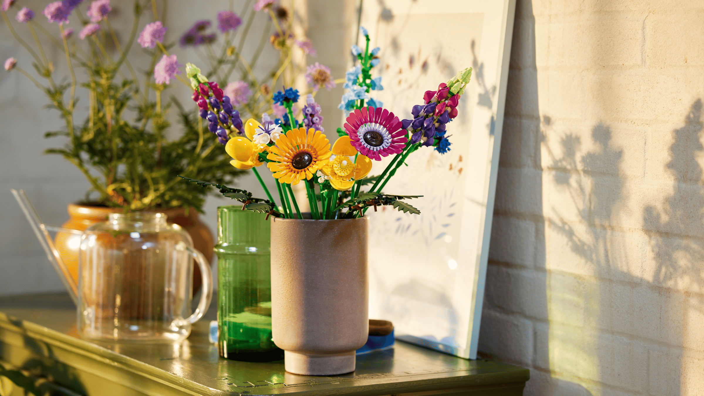 LEGO Wildflower Bouquet set in a stone vase on a green cabinet, caught in warm evening sunlight