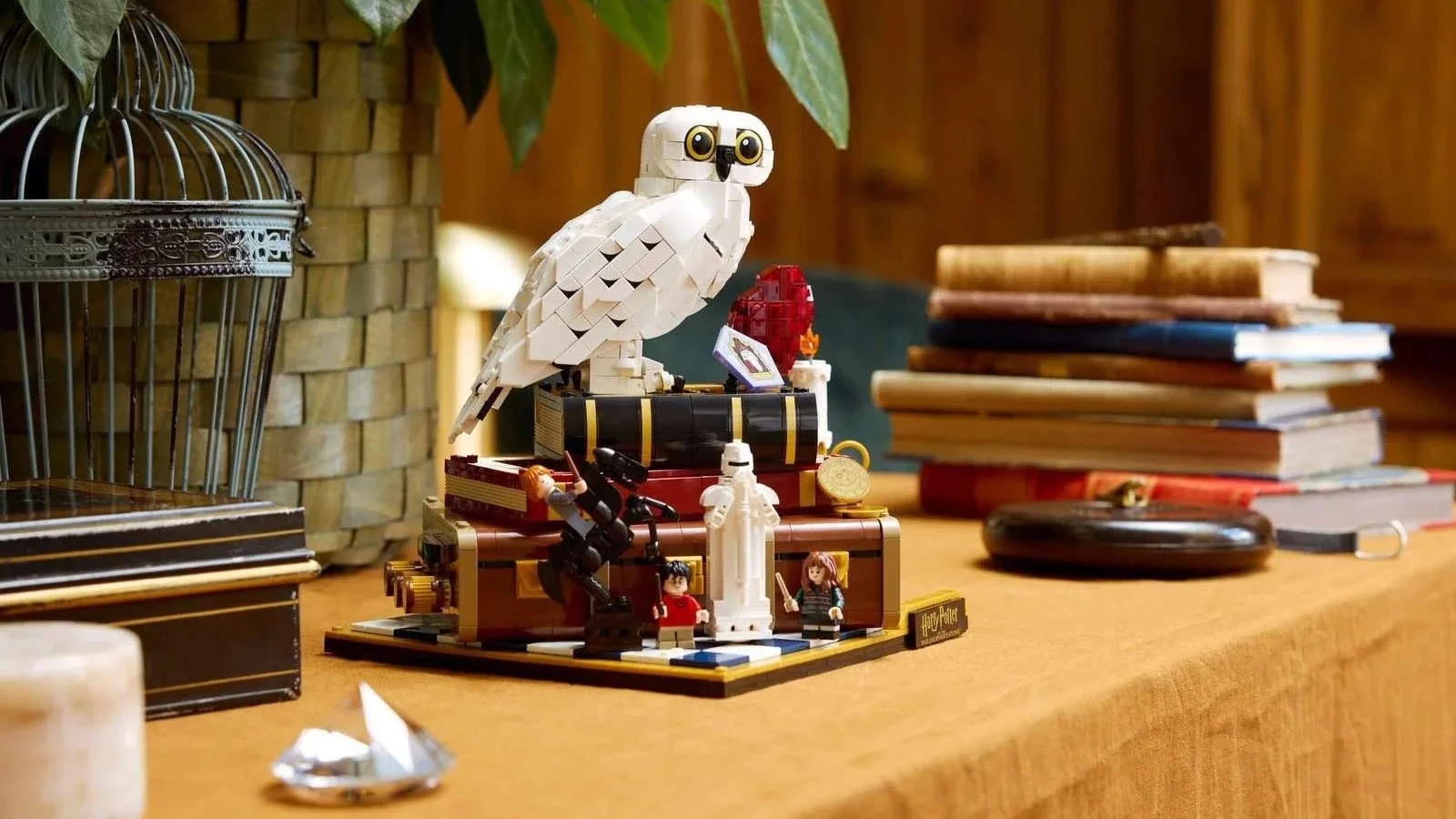 LEGO Sorcerer's Stone – Collectors' Edition set with Hedwig perched atop brick-built trunks on a counter beside old books
