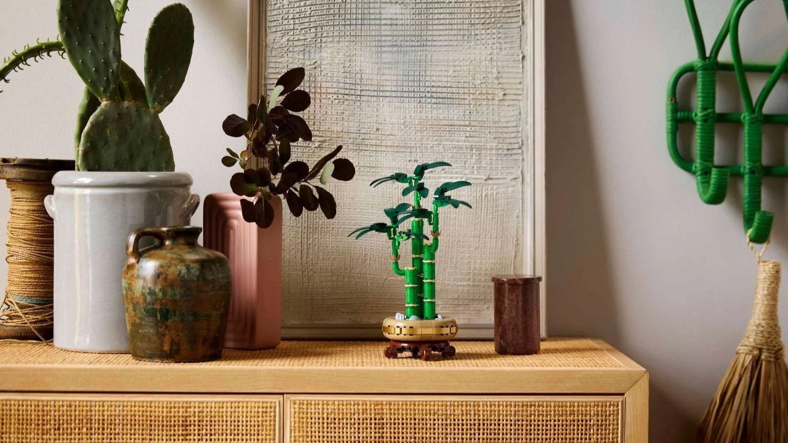 LEGO Lucky Bamboo set in a gold pot styled among ceramic vases on a rattan sideboard