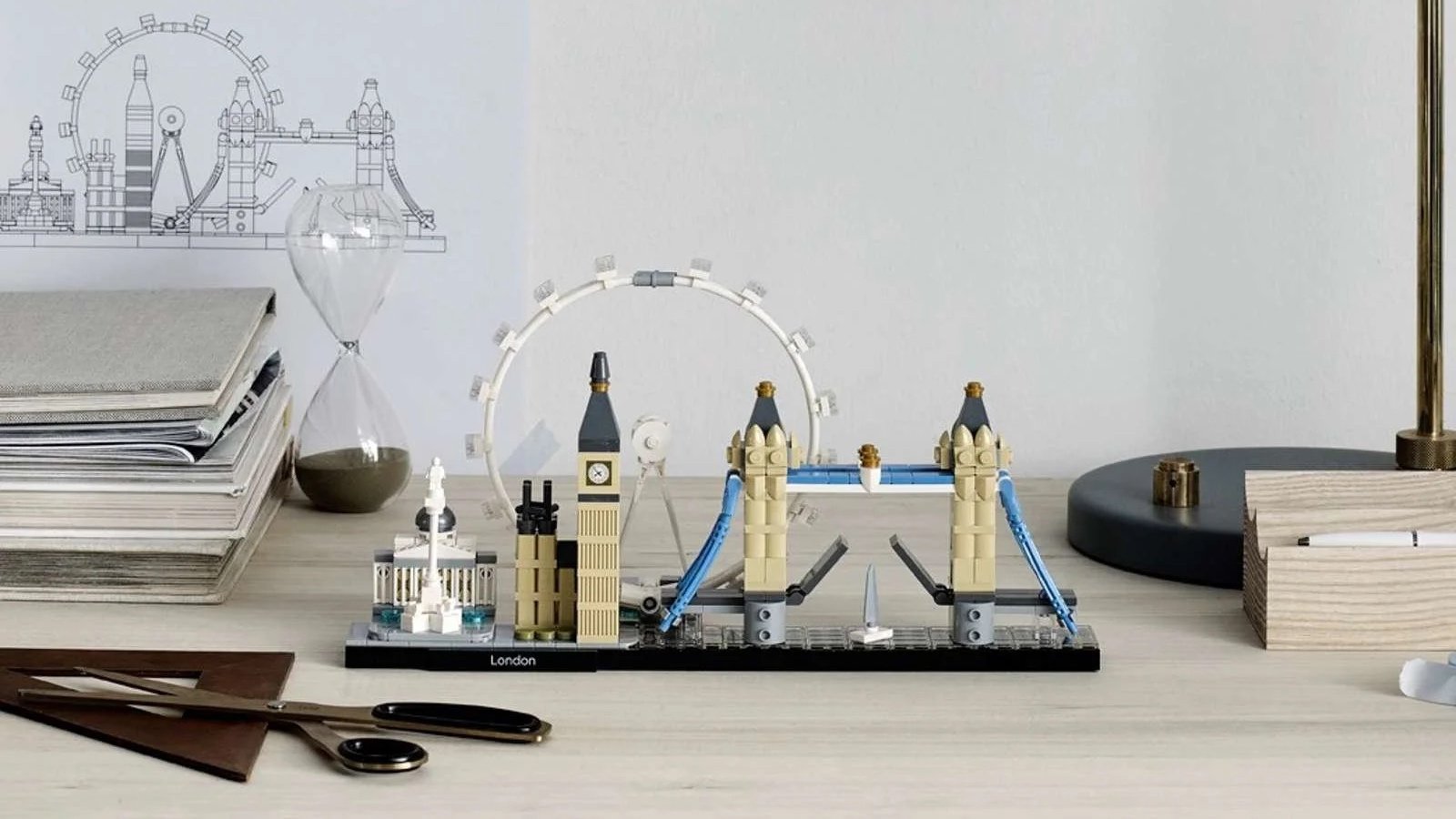 LEGO Architecture London skyline set with Big Ben and Tower Bridge on a desk beside stacked notebooks and an hourglass