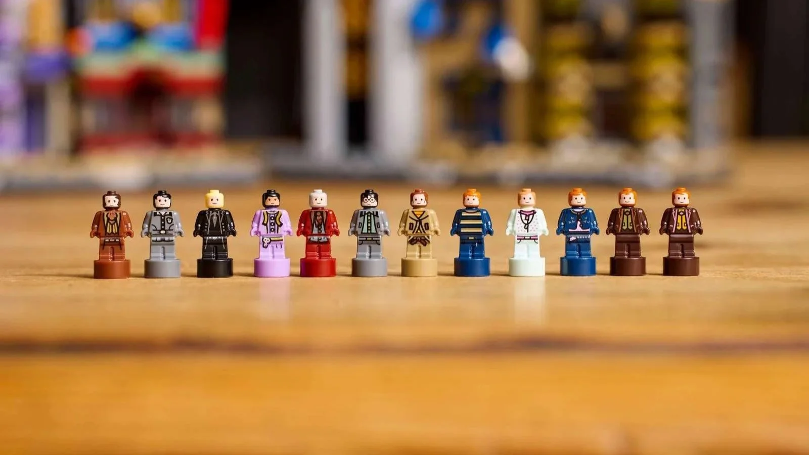 LEGO Harry Potter microfigures lined up on a wooden table in front of a blurred Diagon Alley Wizarding Shops set