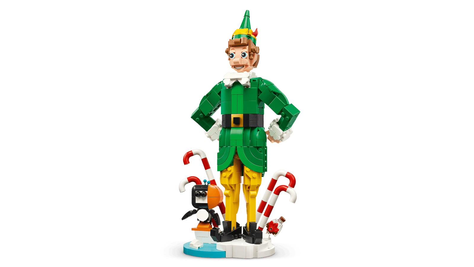 LEGO Buddy the Elf figure in a green suit and yellow tights, hands on hips, standing among candy canes with a small penguin