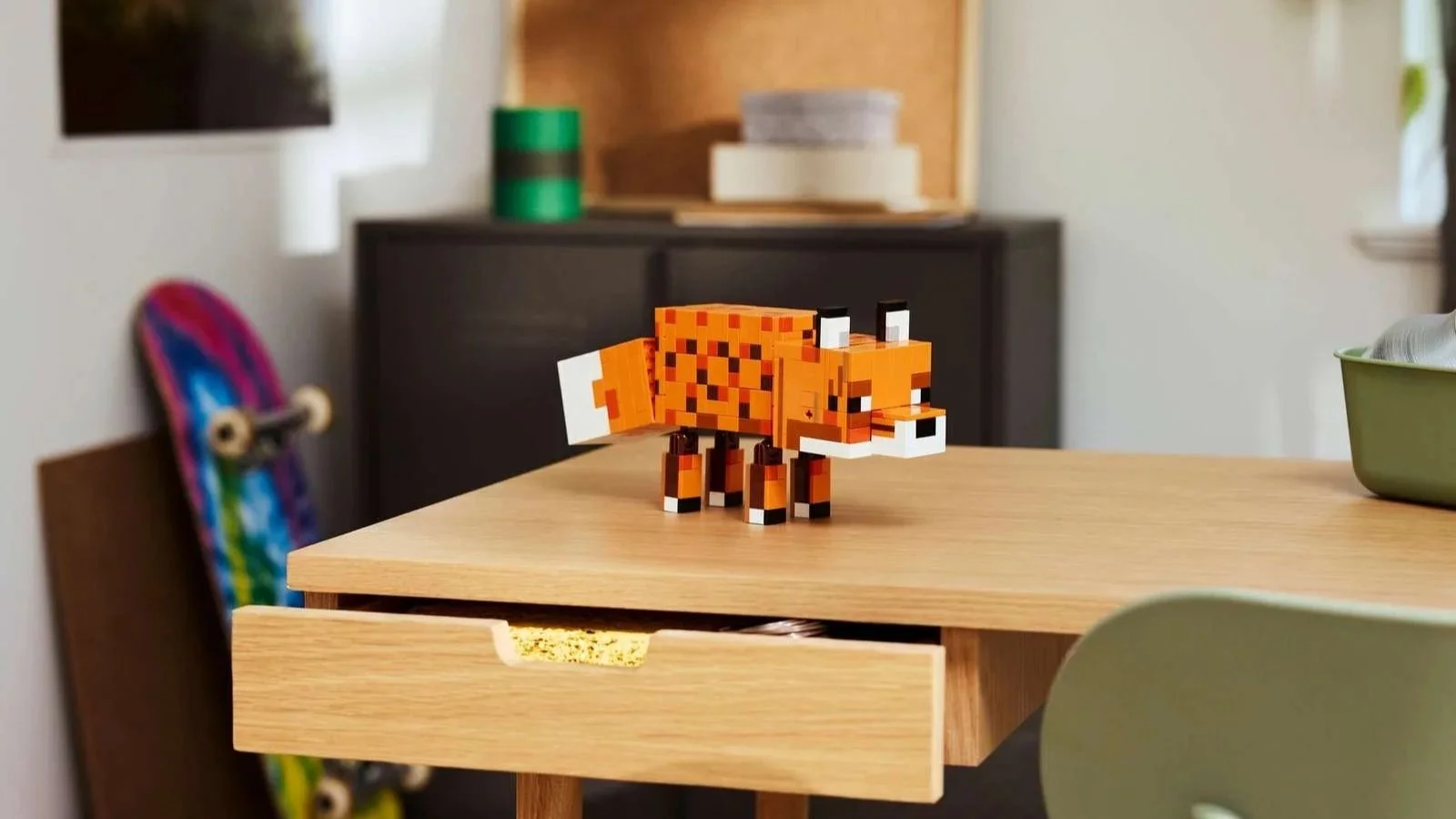 LEGO Minecraft Fox figure on a wood desk, with a skateboard and dresser blurred in the background