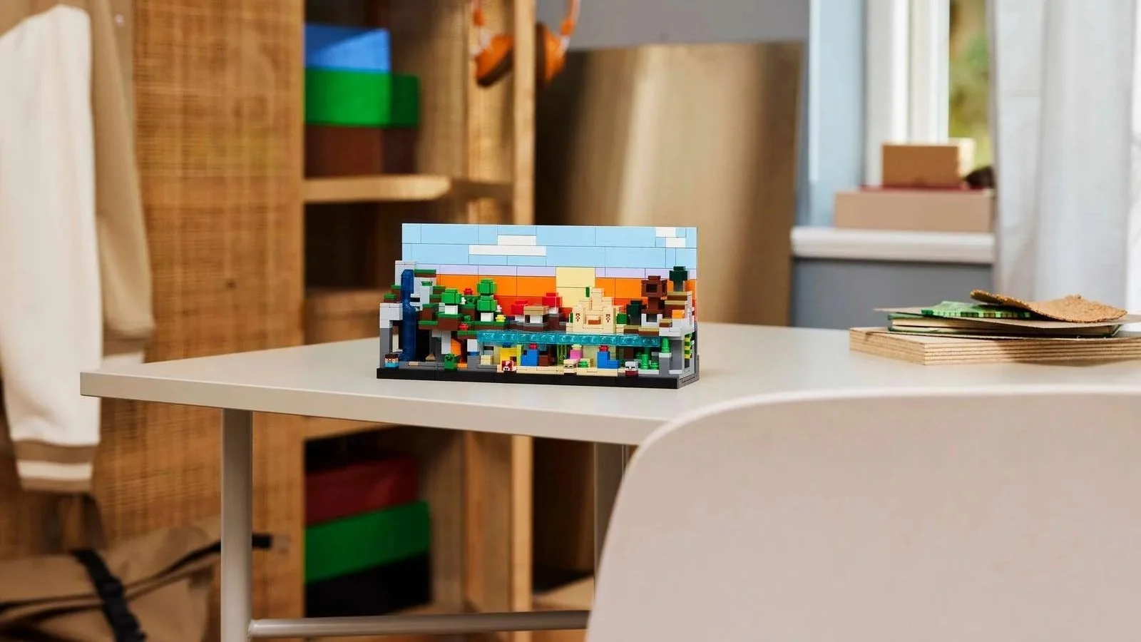 LEGO Minecraft Mini Biomes set with a colorful landscape diorama, arranged on a white desk near a window