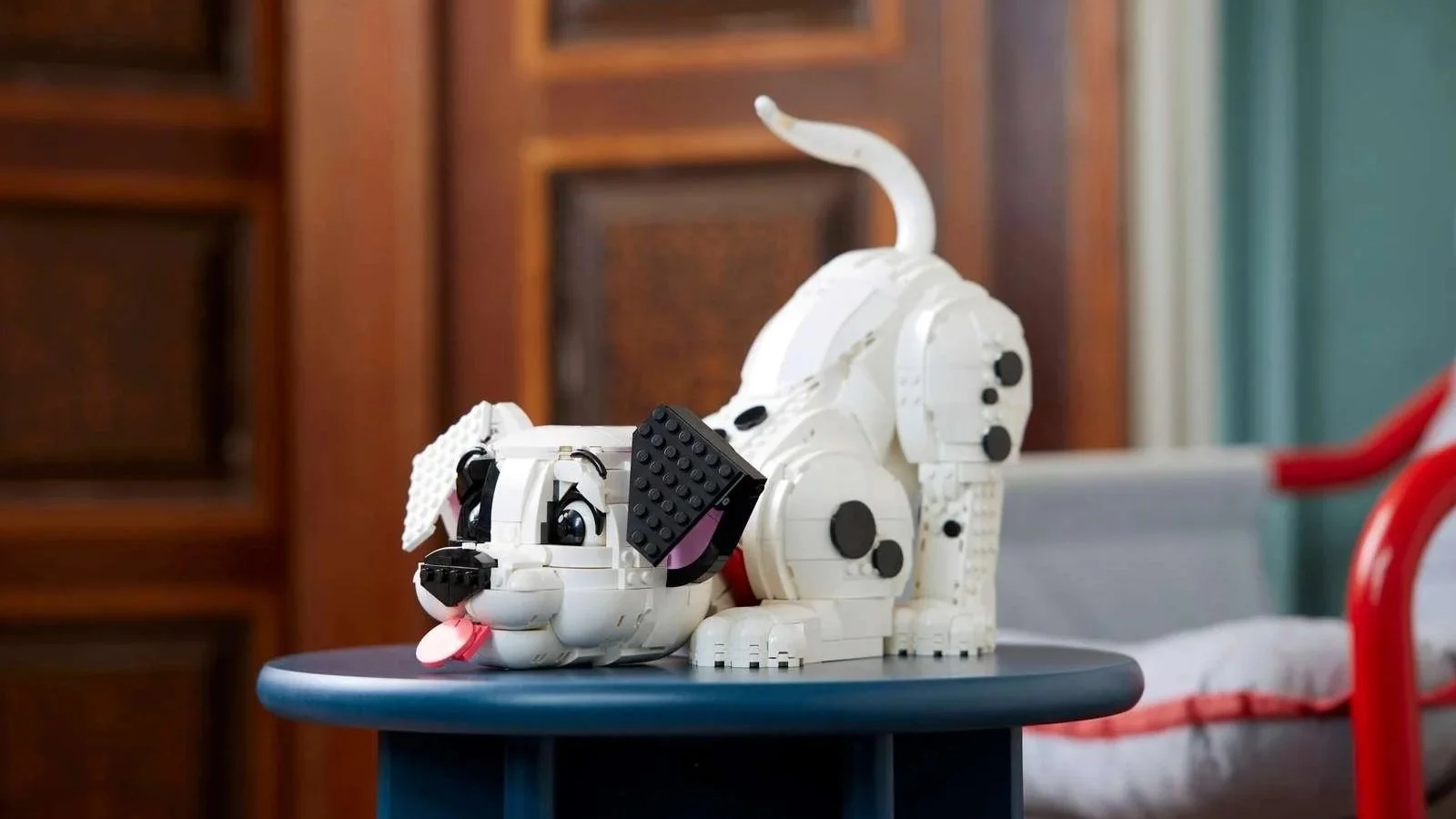 LEGO 101 Dalmatians Puppy set in a playful bow on a navy side table, tail up and tongue out