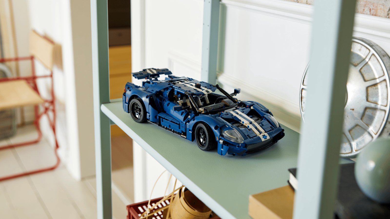 Blue LEGO Technic 2022 Ford GT set with white racing stripes on a pale green shelf