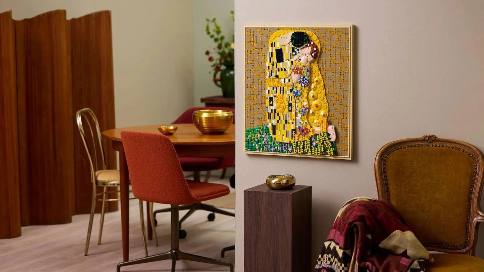 Gustav Klimt's The Kiss as framed LEGO wall art in a mid-century living room with an amber velvet chair