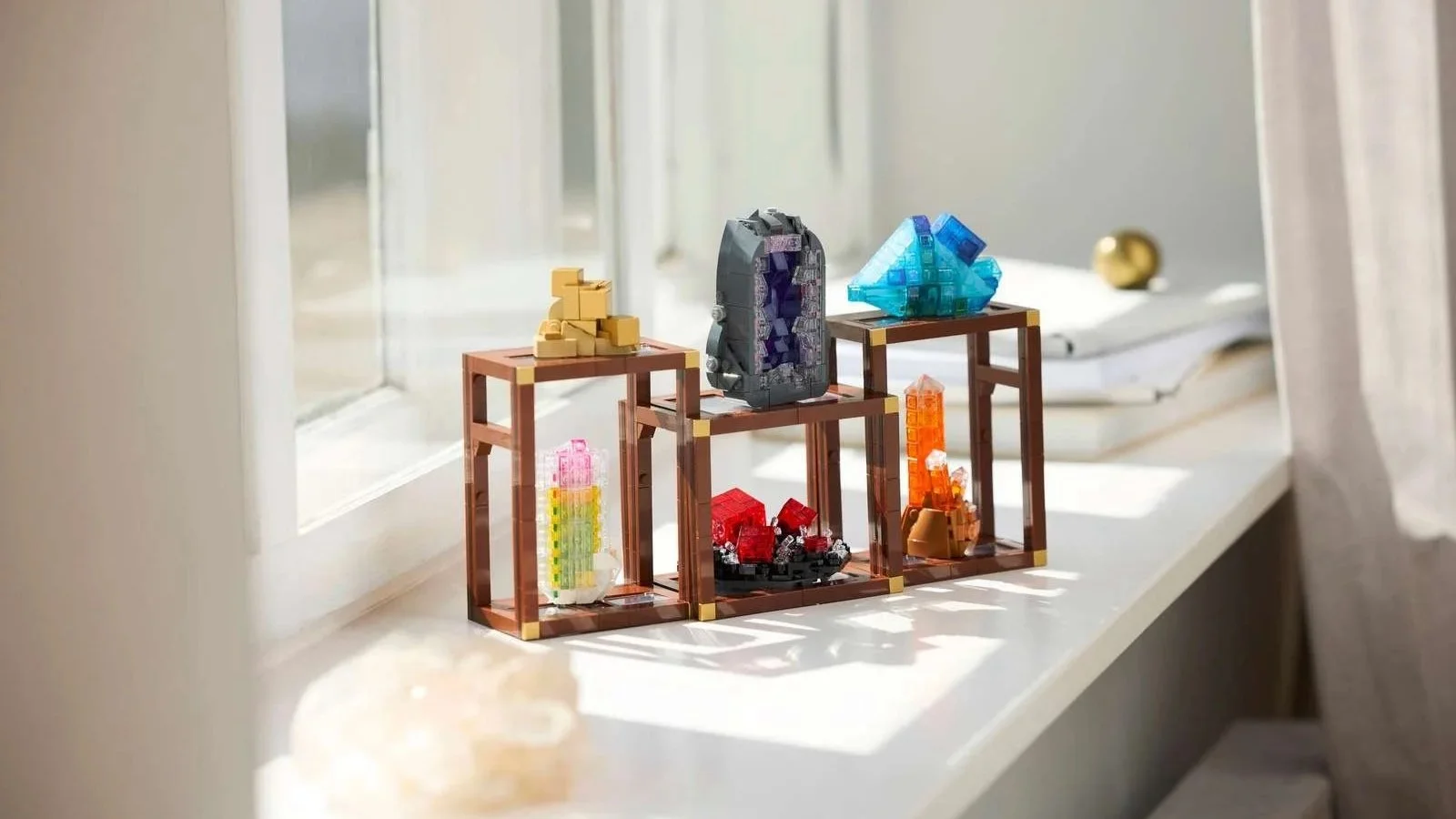 A LEGO Mineral Collection of crystal clusters displayed on tiered stands along a sunlit windowsill