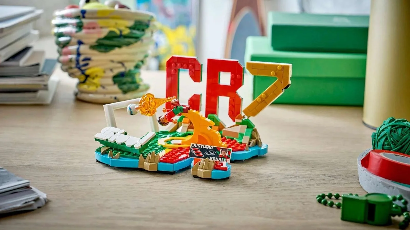 LEGO Cristiano Ronaldo Soccer Highlights set on a desk, with red CR and gold 7 letters above a mini pitch and a bicycle-kick scene